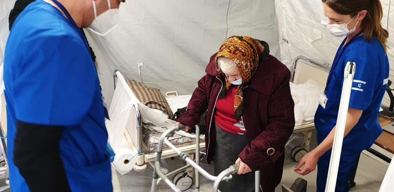 An elderly Ukrainian woman receives her first walker brought from Israel